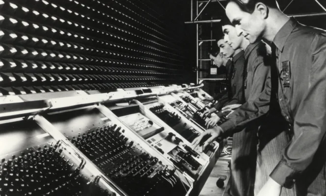 Black and white photo of Kraftwerk in their KlingKlang Studio with a custom-built Synthanorma Modell 316 modular synthesizer.